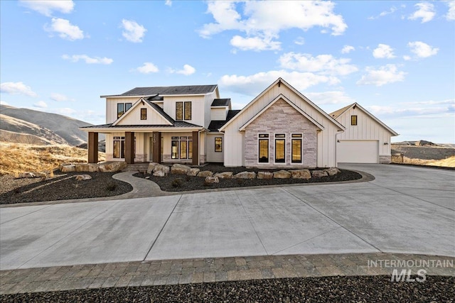 view of front of property featuring a garage, a mountain view, and covered porch