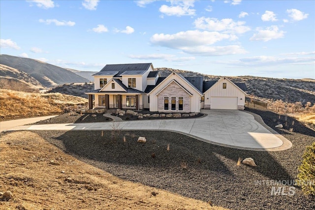 view of front of home featuring a garage, a mountain view, and a porch