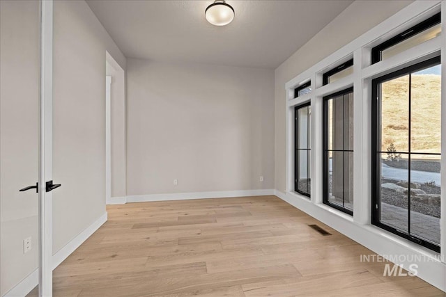 empty room with light hardwood / wood-style flooring