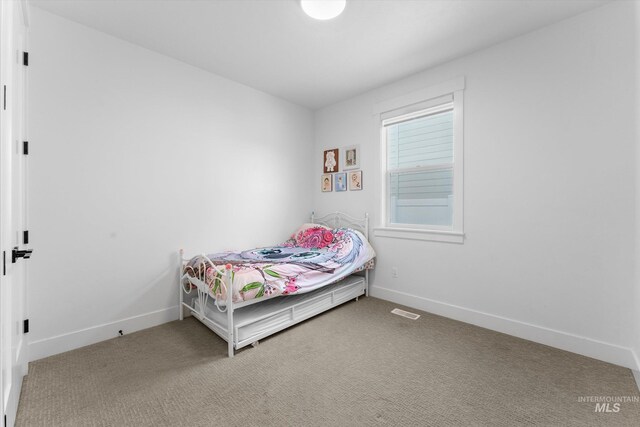 carpeted bedroom featuring baseboards and visible vents