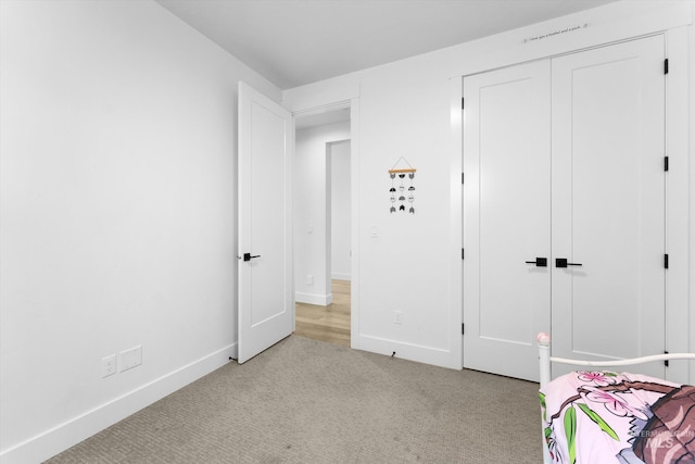 bedroom featuring baseboards, carpet floors, and a closet