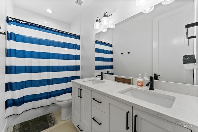 full bath featuring double vanity, visible vents, toilet, and a sink