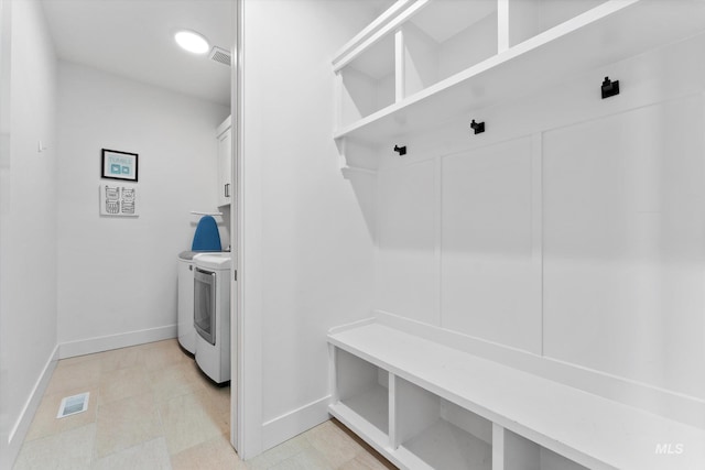 mudroom with washer and dryer, visible vents, and baseboards