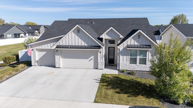 view of front of property with driveway, roof with shingles, board and batten siding, and an attached garage