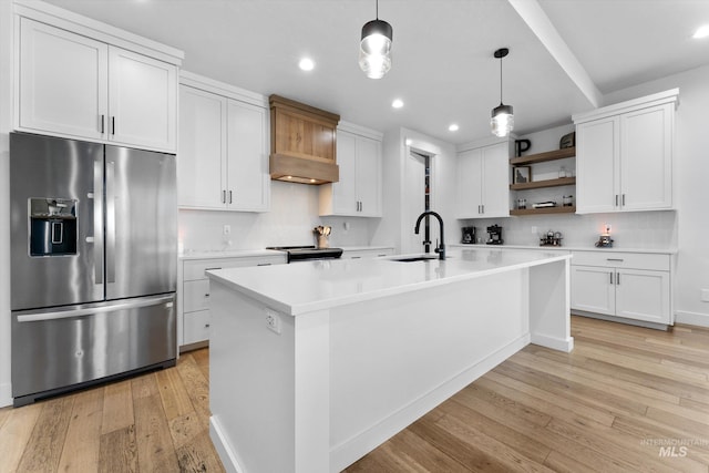 kitchen featuring light wood-style flooring, a sink, open shelves, light countertops, and appliances with stainless steel finishes