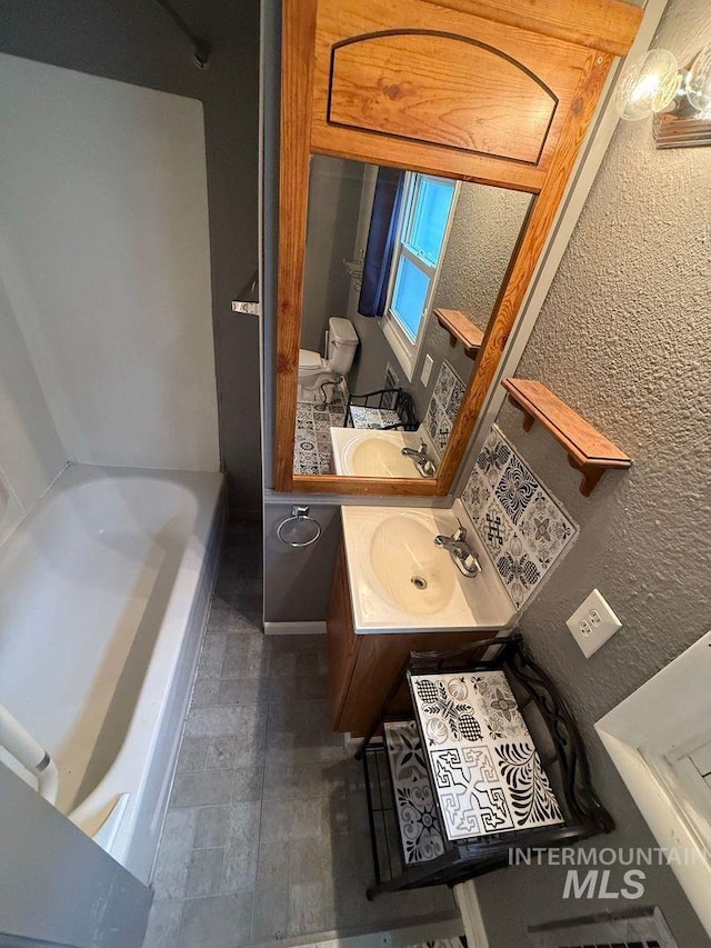 522 Ellis Ave, Winchester, ID 83555 - bathroom with a bathtub, vanity, toilet, and a textured wall