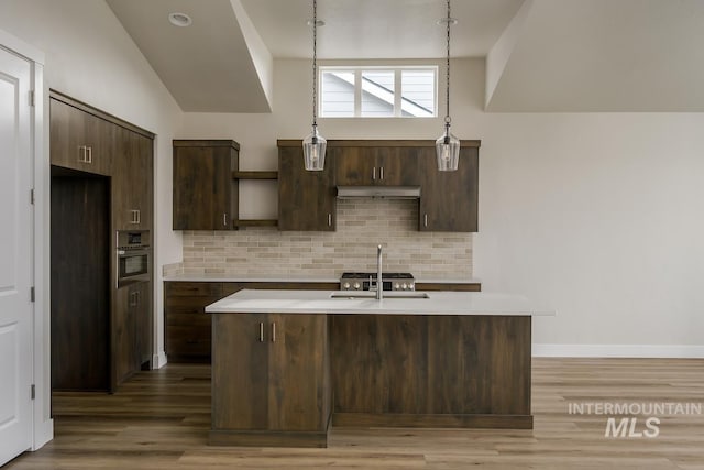 kitchen with dark brown cabinets, wood-type flooring, lofted ceiling, and backsplash