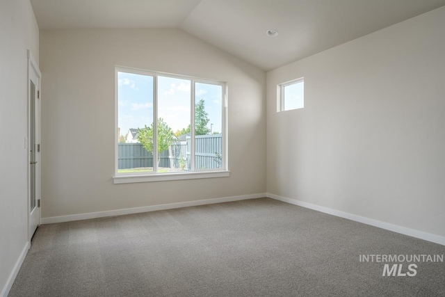 carpeted spare room featuring lofted ceiling