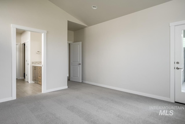 carpeted empty room featuring lofted ceiling