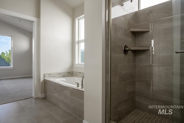 bathroom featuring plus walk in shower and tile patterned flooring