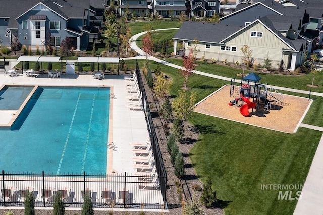 view of pool featuring a playground, a yard, and a patio