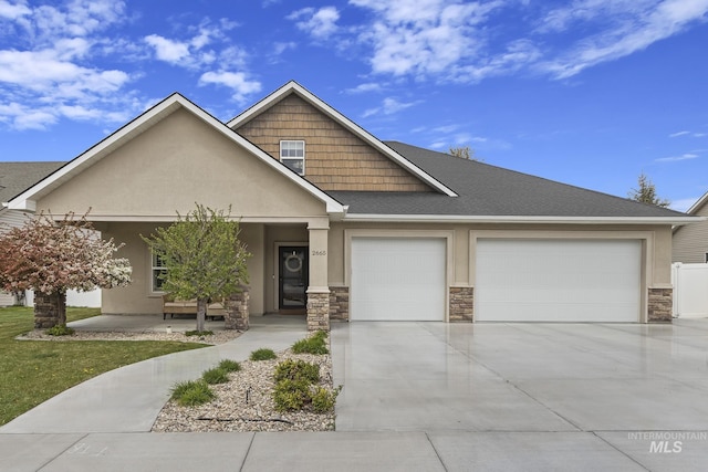 craftsman-style house with a garage, a shingled roof, stone siding, concrete driveway, and stucco siding