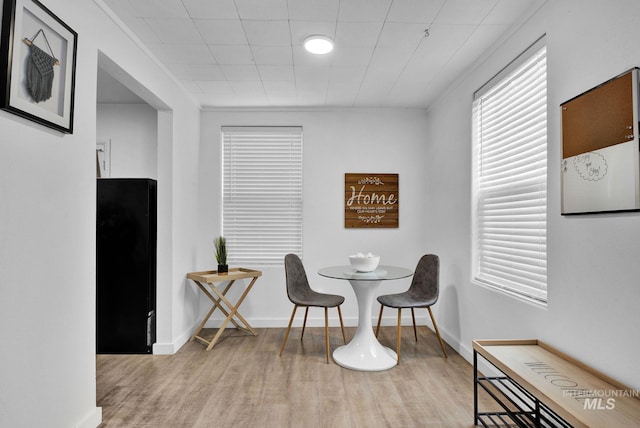 dining room featuring light wood finished floors and baseboards