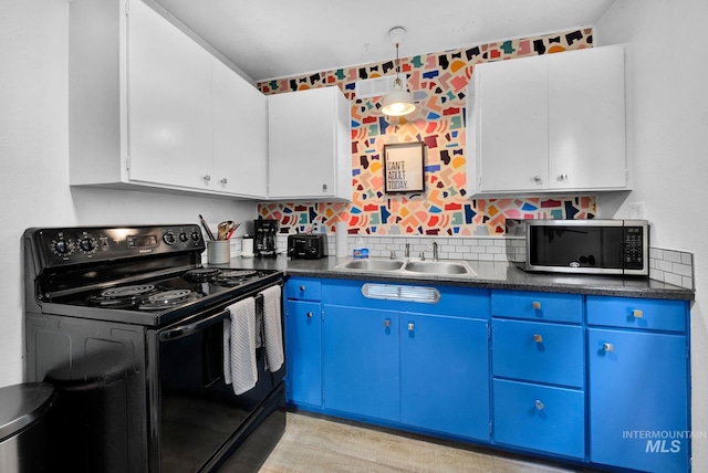 kitchen with dark countertops, stainless steel microwave, white cabinetry, blue cabinets, and black range with electric cooktop