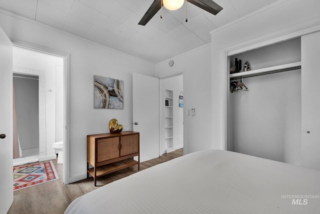 bedroom with connected bathroom, a ceiling fan, wood finished floors, crown molding, and a closet