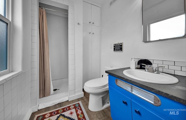 full bathroom with visible vents, toilet, a shower stall, vanity, and wood finished floors