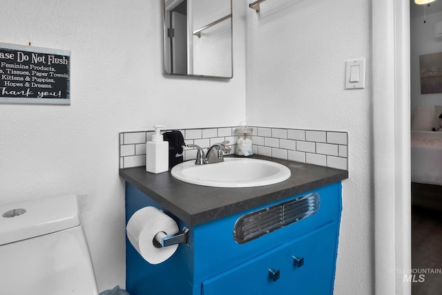 ensuite bathroom featuring decorative backsplash, toilet, vanity, and ensuite bath