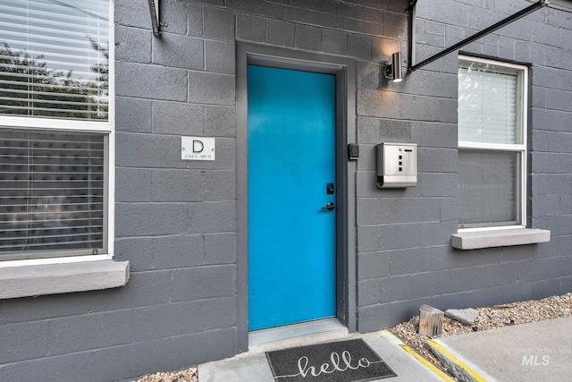 doorway to property featuring concrete block siding