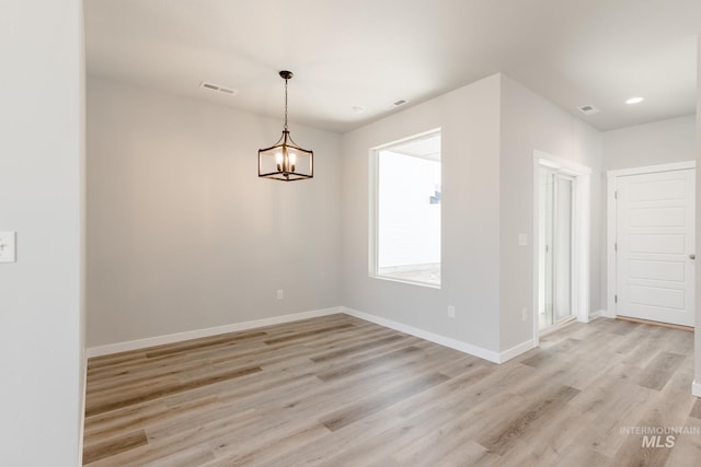 4435 N Magical Creek Ave, Meridian, ID 83646 - empty room with an inviting chandelier, baseboards, visible vents, and light wood-style floors