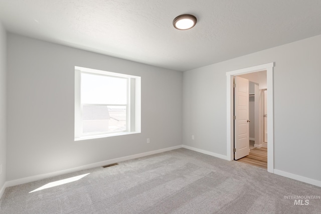 4435 N Magical Creek Ave, Meridian, ID 83646 - unfurnished bedroom featuring baseboards, carpet flooring, visible vents, and a textured ceiling
