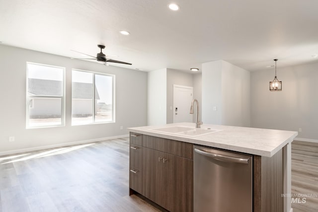 4435 N Magical Creek Ave, Meridian, ID 83646 - kitchen with dishwasher, baseboards, a sink, a center island with sink, and light countertops