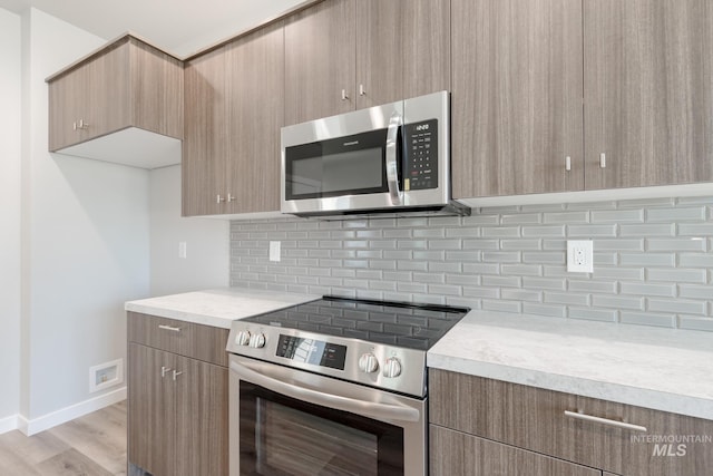 4435 N Magical Creek Ave, Meridian, ID 83646 - kitchen with light countertops, appliances with stainless steel finishes, decorative backsplash, and modern cabinets
