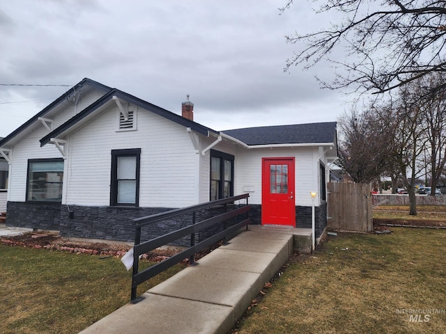 108 Morrison, Caldwell, ID 83605 - view of front of home featuring a chimney, stone siding, and a shingled roof