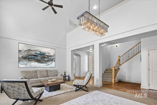 6370 E Escarpment Ct, Boise, ID 83716 - living room with a high ceiling, stairway, ceiling fan, arched walkways, and baseboards