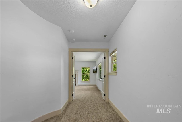 6370 E Escarpment Ct, Boise, ID 83716 - hallway featuring baseboards, light carpet, and a textured ceiling