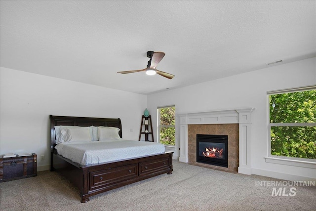 6370 E Escarpment Ct, Boise, ID 83716 - bedroom with multiple windows, light colored carpet, a fireplace, and a ceiling fan