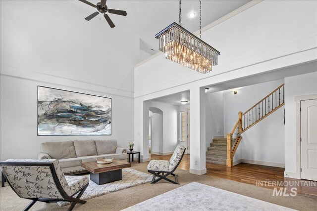 6370 E Escarpment Ct, Boise, ID 83716 - living room with a high ceiling, stairway, ceiling fan, arched walkways, and baseboards