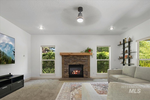 6370 E Escarpment Ct, Boise, ID 83716 - living area with a stone fireplace, carpet flooring, plenty of natural light, baseboards, and a textured ceiling
