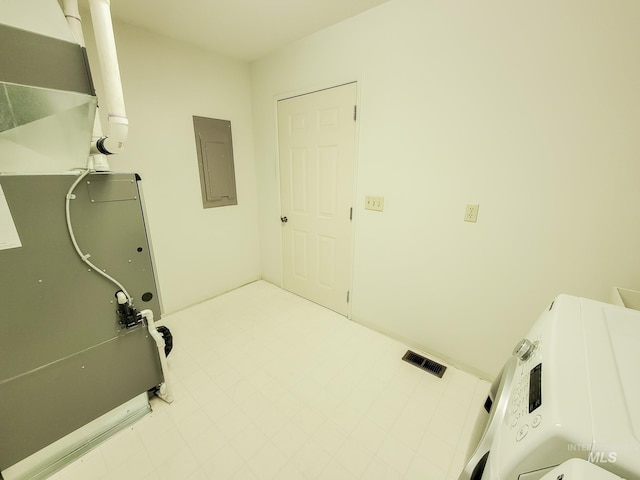 clothes washing area featuring visible vents, electric panel, laundry area, heating unit, and washer / clothes dryer