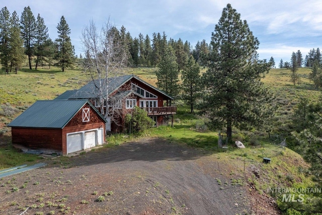 view of front of property featuring an outbuilding, driveway, and a wooden deck