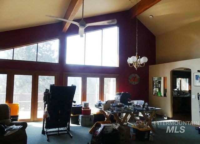 living room with arched walkways, carpet, high vaulted ceiling, beam ceiling, and ceiling fan with notable chandelier