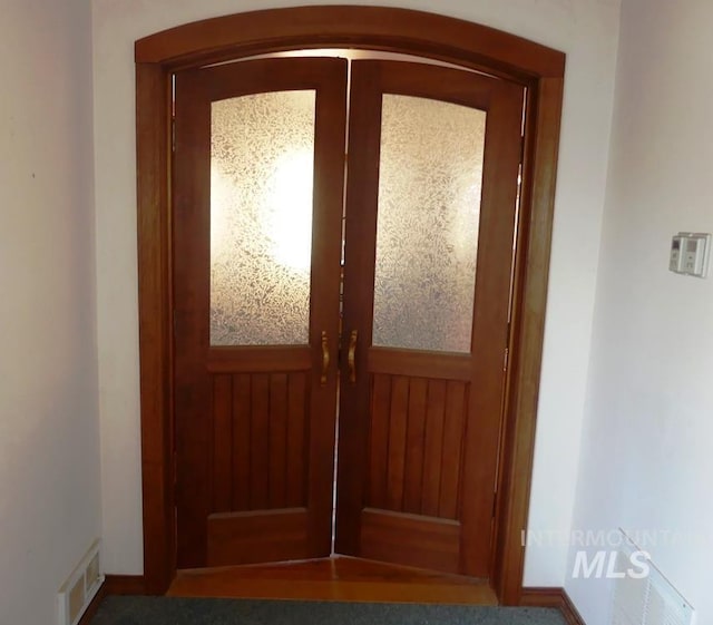 interior space with a wainscoted wall and visible vents