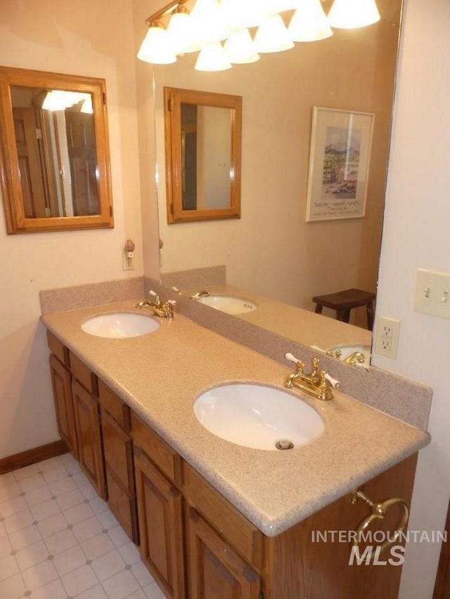 bathroom featuring a sink, baseboards, and double vanity