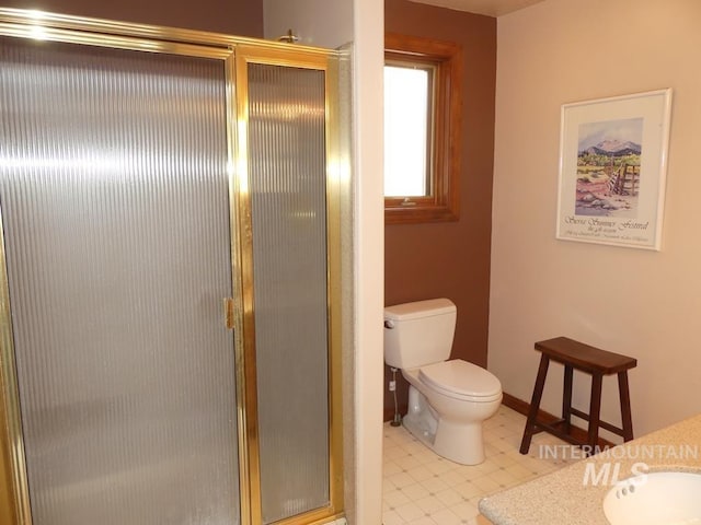 full bath with toilet, a stall shower, vanity, baseboards, and tile patterned floors