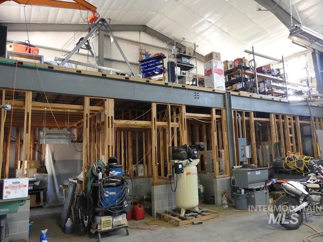 miscellaneous room with a garage, concrete floors, and vaulted ceiling