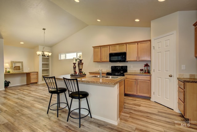 kitchen with a center island with sink, a breakfast bar, light wood-style flooring, a sink, and black appliances