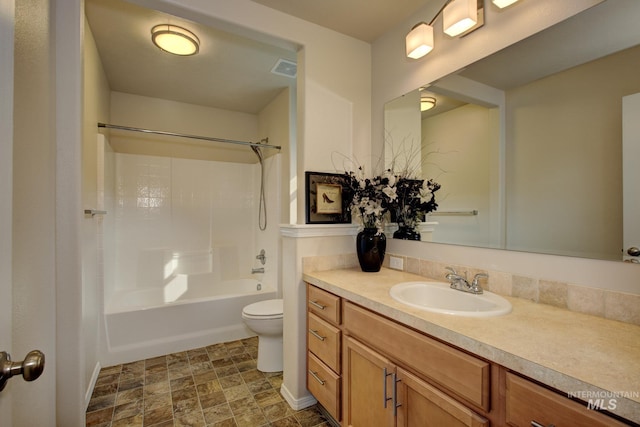 bathroom featuring vanity, visible vents,  shower combination, stone finish floor, and toilet