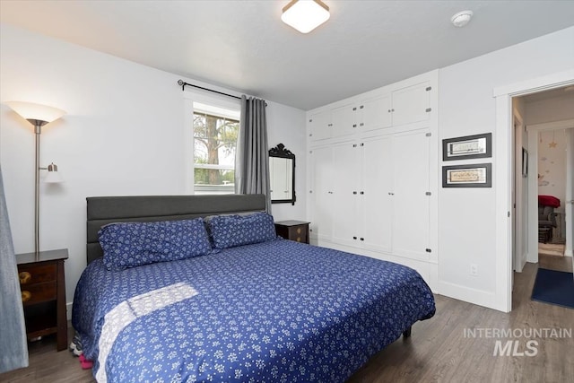 bedroom featuring baseboards, a closet, and wood finished floors
