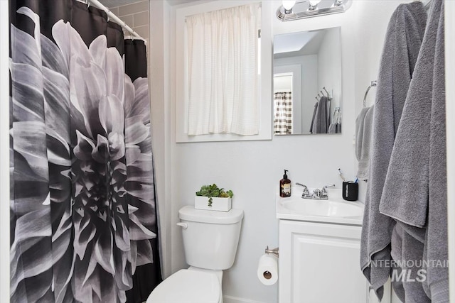full bathroom with toilet, vanity, and curtained shower