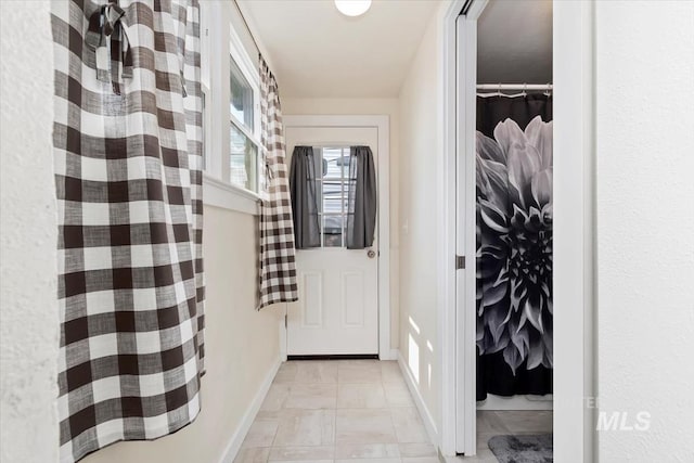 doorway to outside with baseboards