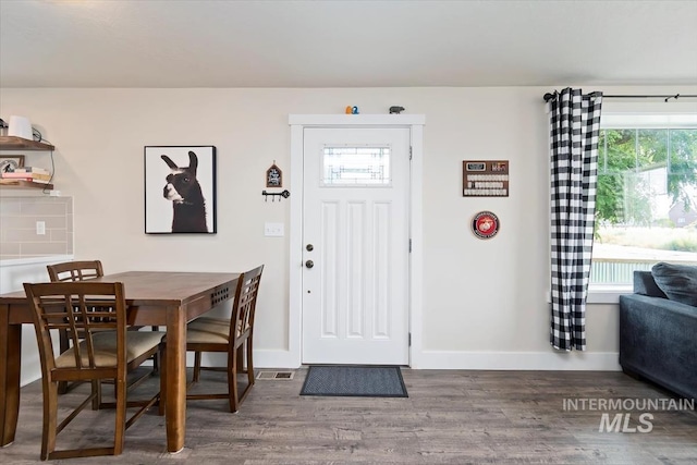 foyer with baseboards and wood finished floors