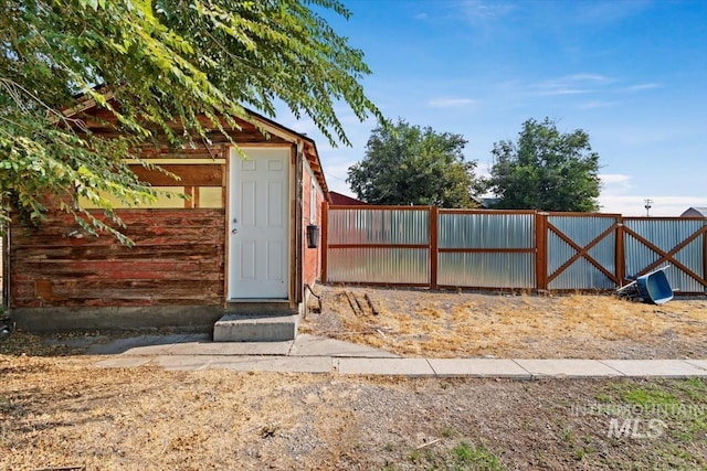 view of outbuilding featuring a gate and fence