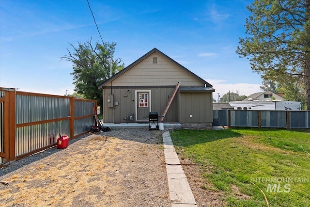 rear view of property featuring a lawn, fence, board and batten siding, and a patio