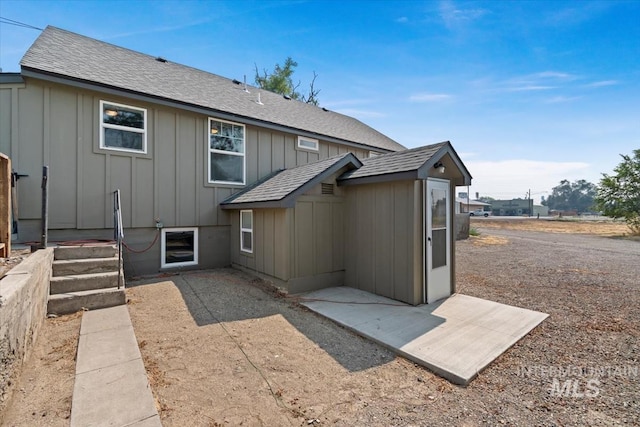 back of property featuring board and batten siding and a shingled roof