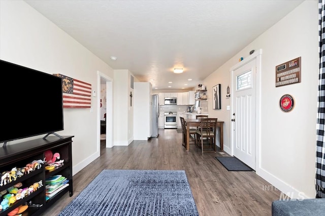 entryway with dark wood-style floors and baseboards