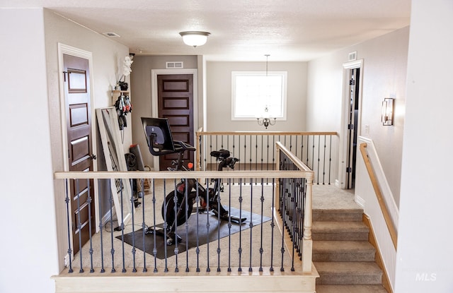 staircase featuring carpet and a textured ceiling